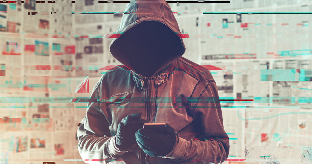 Hooded hacker person using smartphone in infodemic concept with digital glitch effect